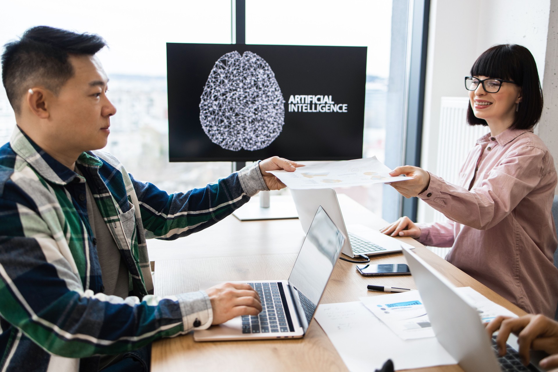Coworkers collaborating on artificial intelligence project in modern office